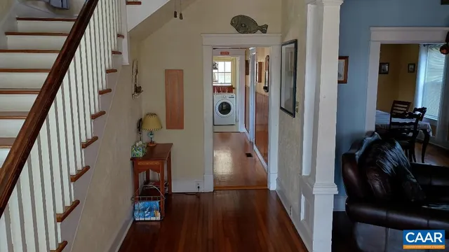 a view of a hallway with wooden floor and stairs