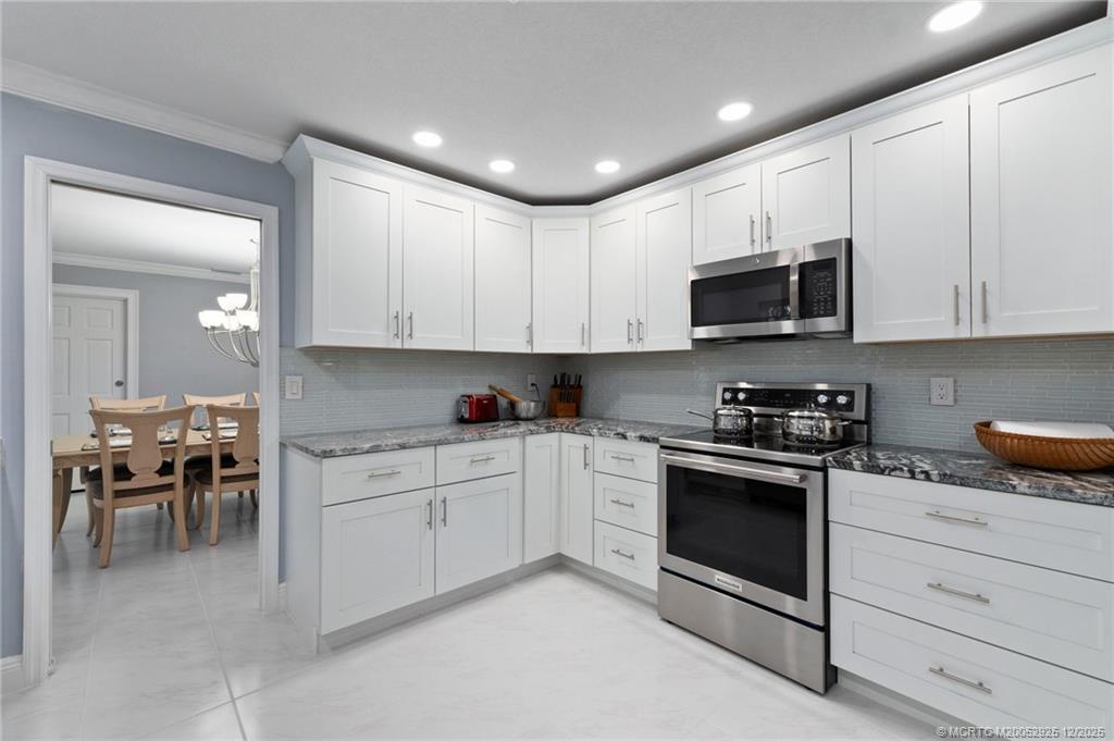 20 Banyan Road Stuart, FL 34996 - Photo 23 of 95 a kitchen with stainless steel appliances granite countertop a stove a sink and a microwave