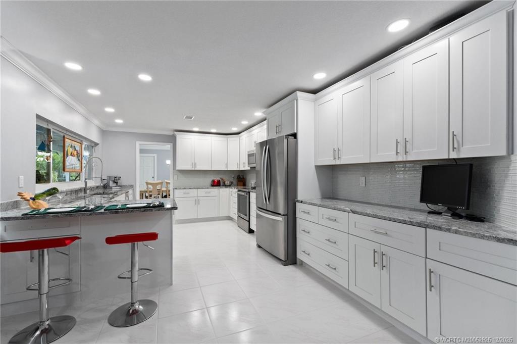 20 Banyan Road Stuart, FL 34996 - Photo 24 of 95 a kitchen with stainless steel appliances granite countertop a refrigerator sink and cabinets