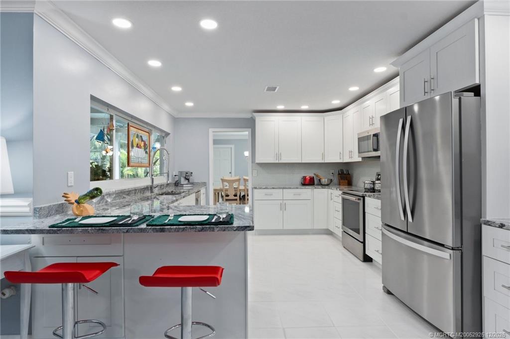 20 Banyan Road Stuart, FL 34996 - Photo 25 of 95 a kitchen with stainless steel appliances granite countertop a refrigerator and a stove top oven