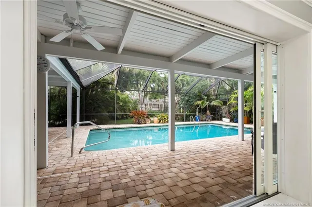 a room with pool table and glass windows