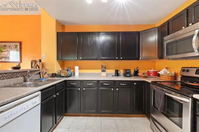 a kitchen with stainless steel appliances a stove a sink and a microwave