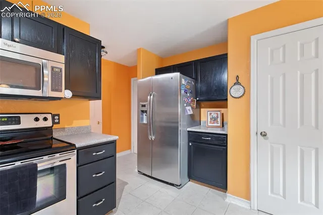 a kitchen with stainless steel appliances granite countertop a refrigerator and a stove