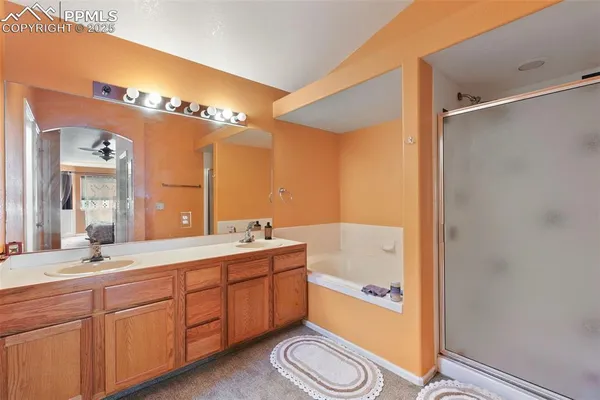 a bathroom with a double vanity sink and mirror with bathtub