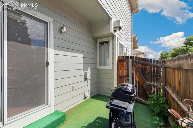 a view of a house with a backyard and wooden fence