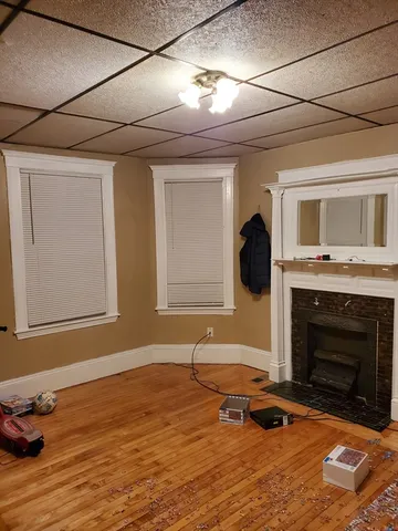 a living room with fireplace furniture and a wooden floor
