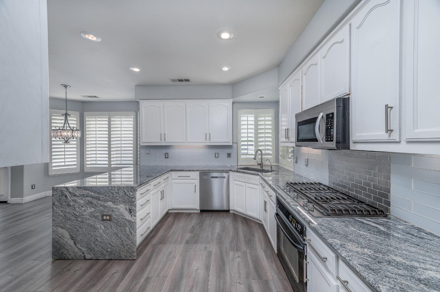 2800 Olympus Court Modesto, CA 95356 - Photo 13 of 56 a large kitchen with stainless steel appliances granite countertop a stove and a sink