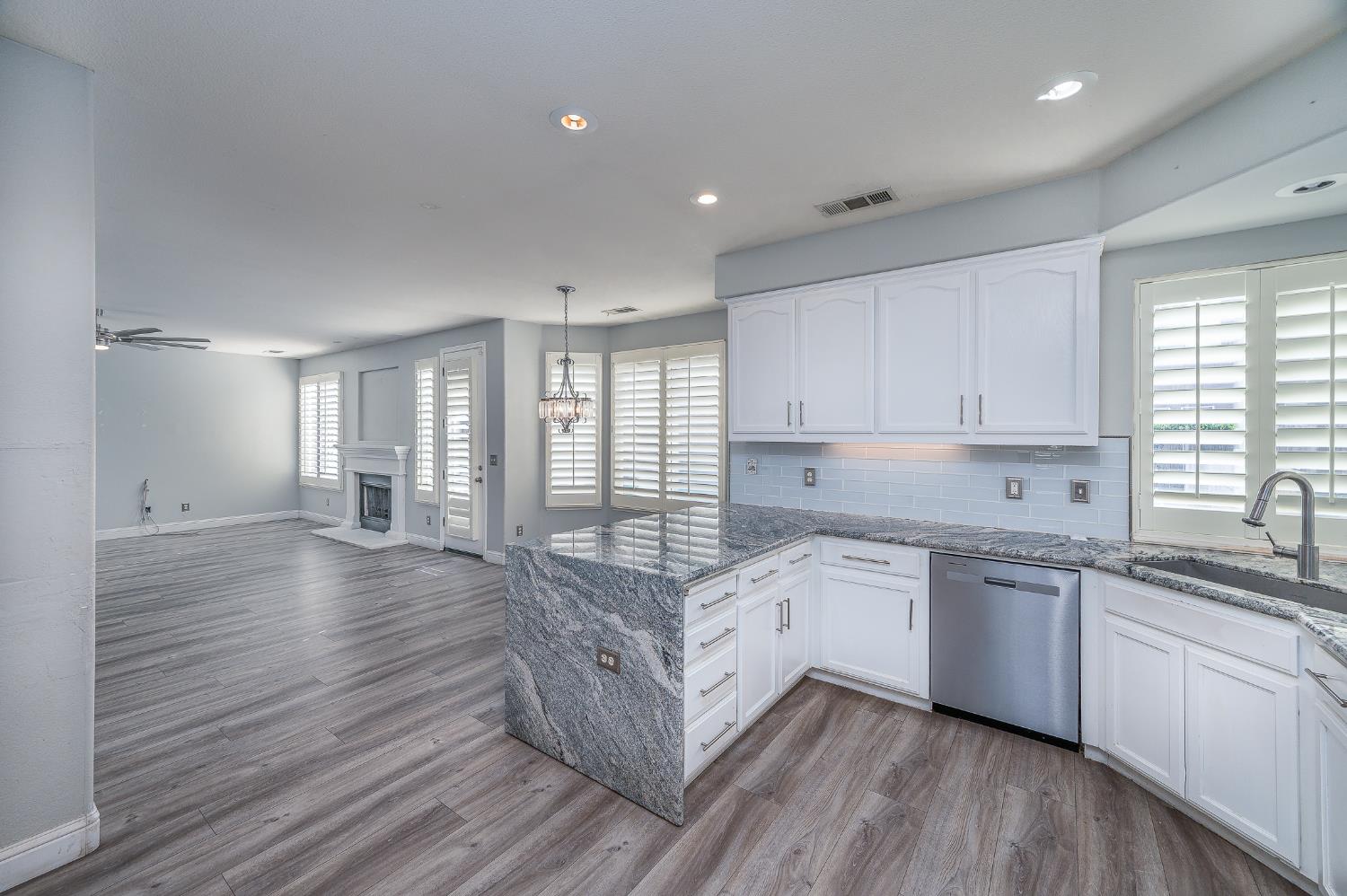 2800 Olympus Court Modesto, CA 95356 - Photo 20 of 56 a large kitchen with granite countertop a stove top oven a sink with wooden floors and cabinets