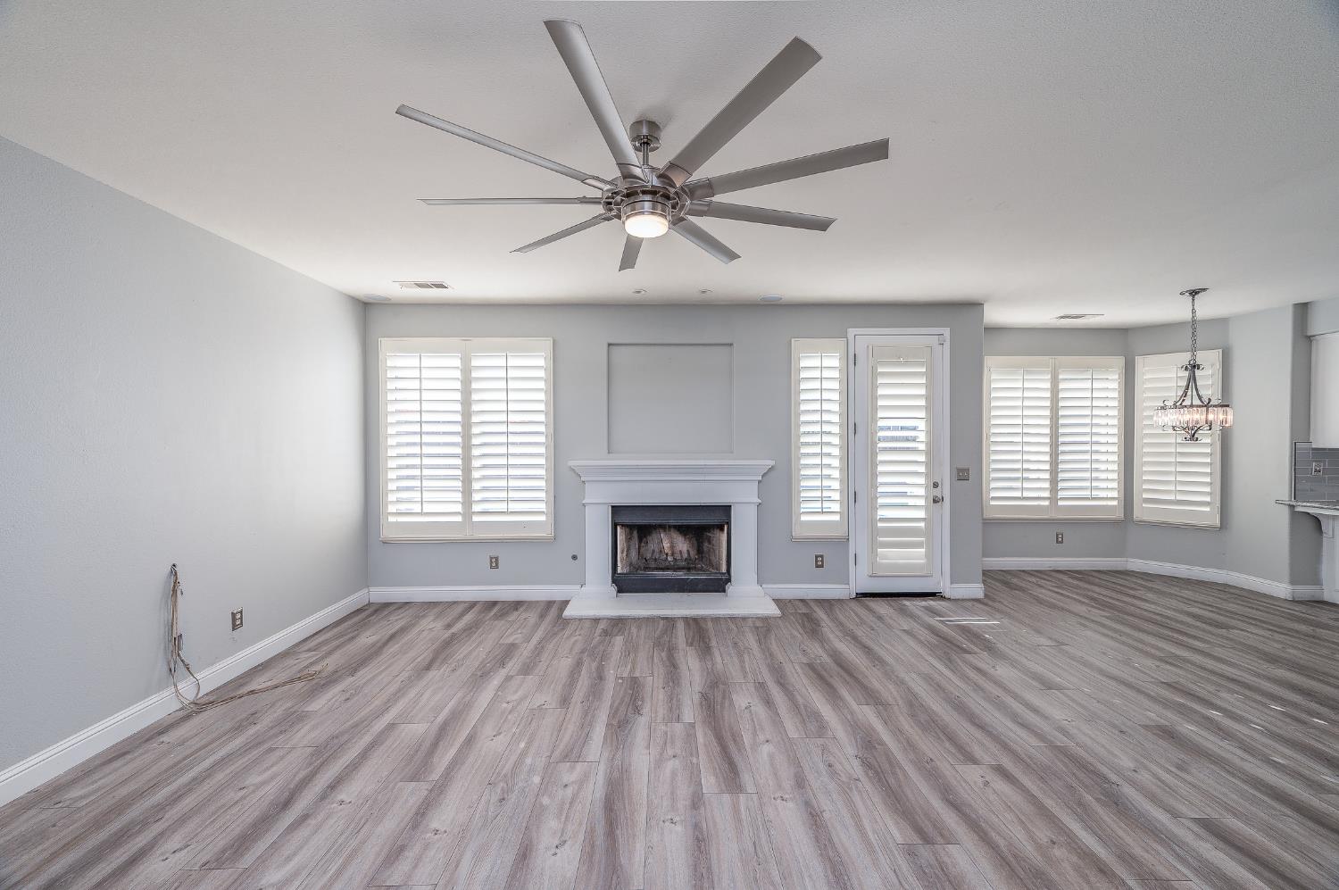 2800 Olympus Court Modesto, CA 95356 - Photo 23 of 56 wooden floor fireplace and windows in an empty room
