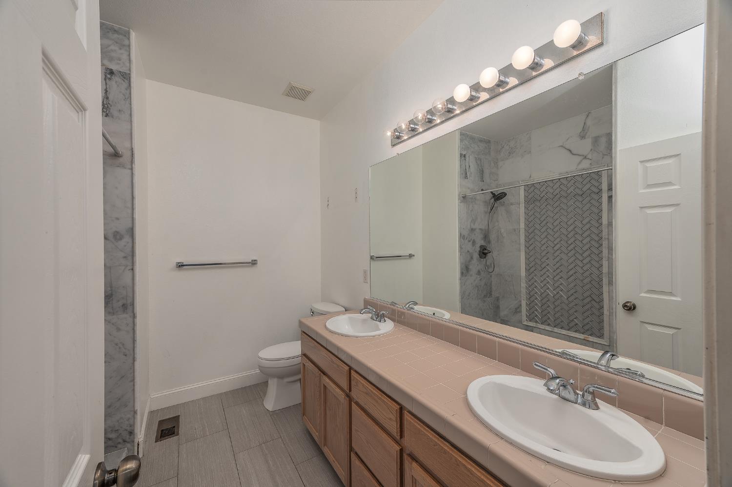 2800 Olympus Court Modesto, CA 95356 - Photo 52 of 56 a bathroom with a sink double vanity granite and a mirror