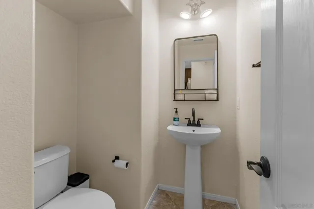 a bathroom with a sink mirror and toilet