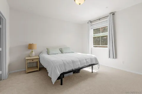 a bed sitting in a bedroom next to a window