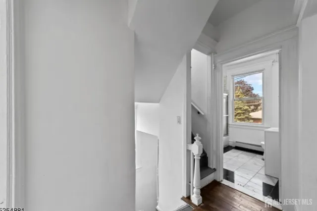 a view of an entryway with wooden floor and a livingroom