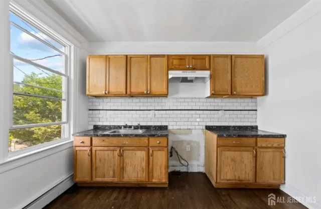 a kitchen with a sink a window and cabinets