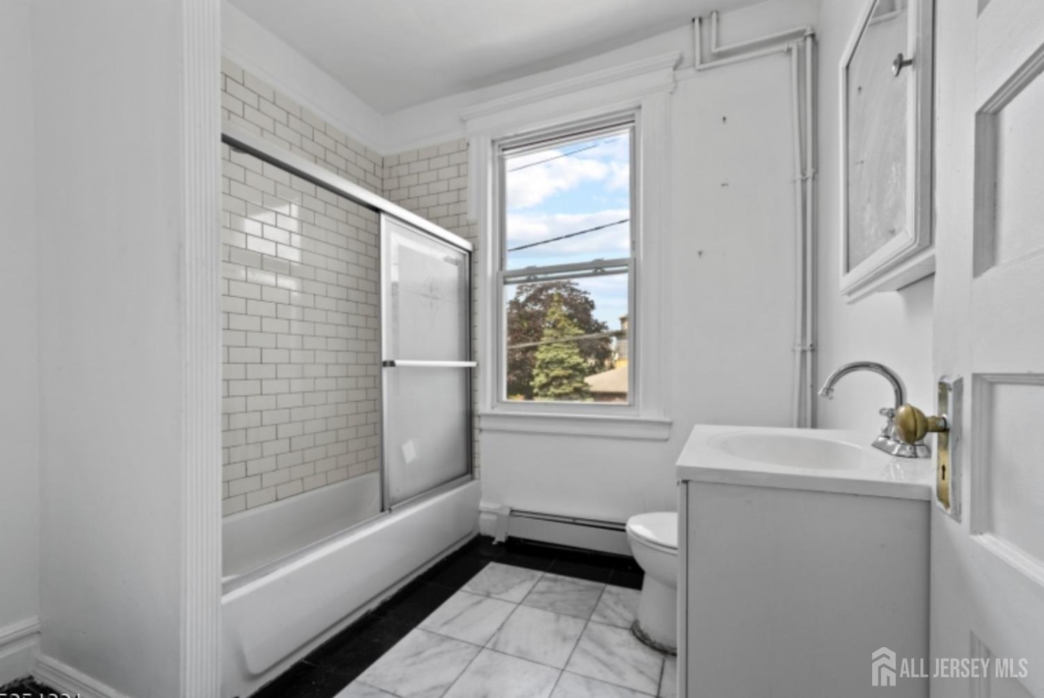 410 Chadwick Avenue, Unit 2 Newark, NJ 07112 - Photo 7 of 11 a bathroom with a sink a toilet and shower