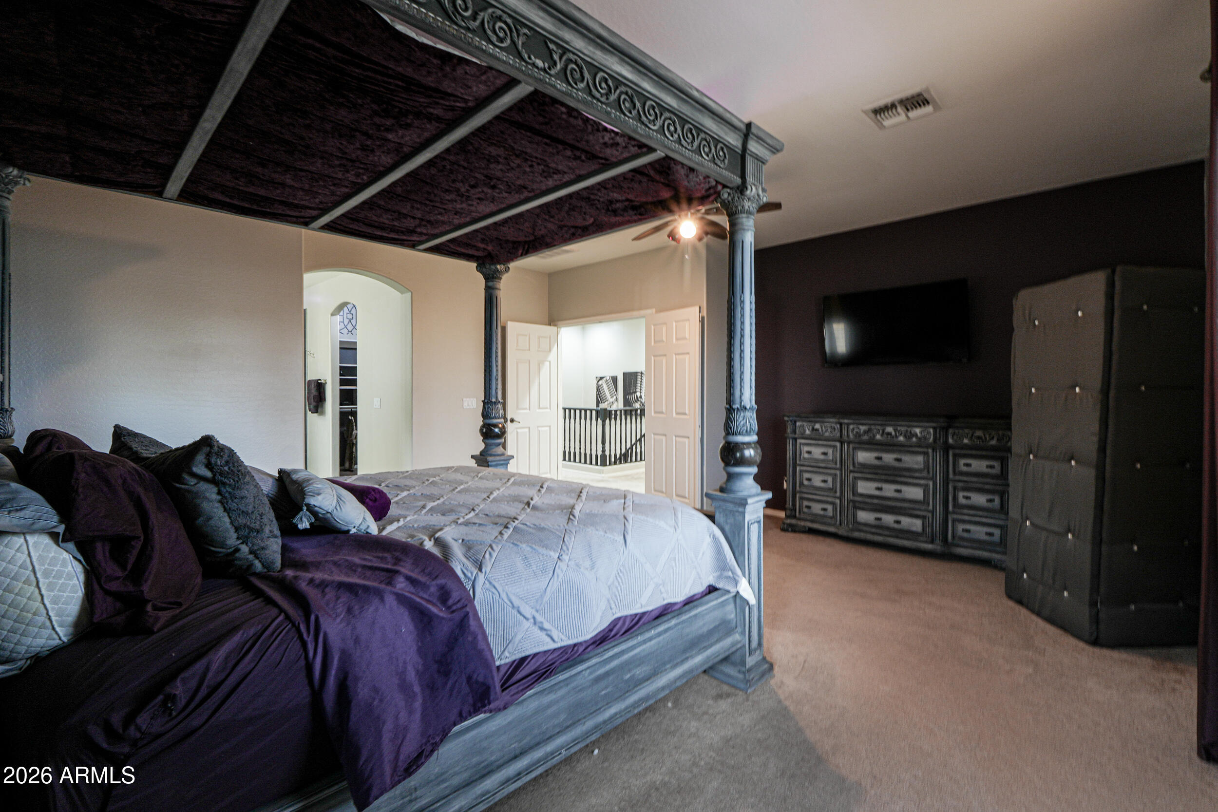 45247 West Jack Rabbit Trail Maricopa, AZ 85139 - Photo 51 of 75 a spacious bedroom with a bed a mirror and a television