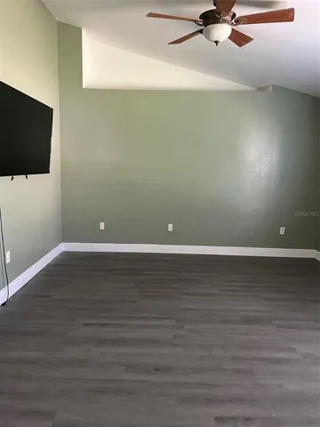 a view of a room with wooden floor and fan