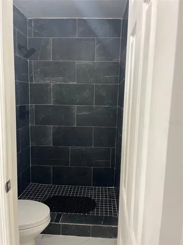 a bathroom with a toilet and a shower
