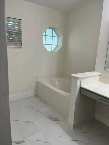 a white bath tub sitting next to a white sink