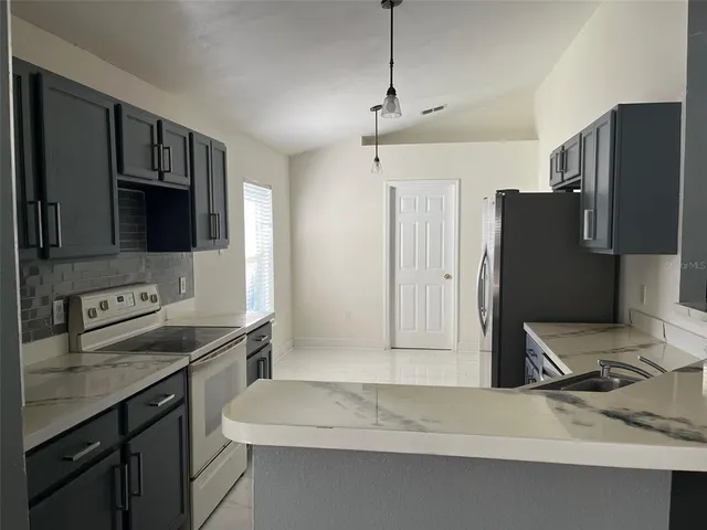 a kitchen with stainless steel appliances a sink stove and refrigerator
