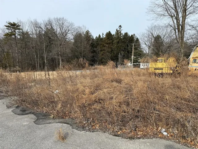 a view of a yard with wooden fence