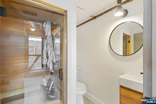 a bathroom with a granite countertop sink mirror vanity and toilet