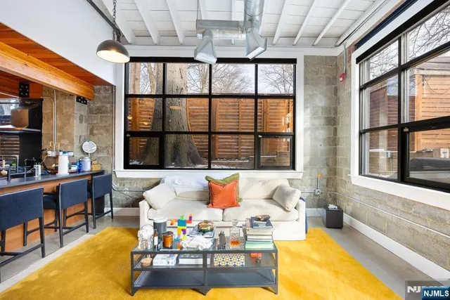 a living room filled with furniture and large windows