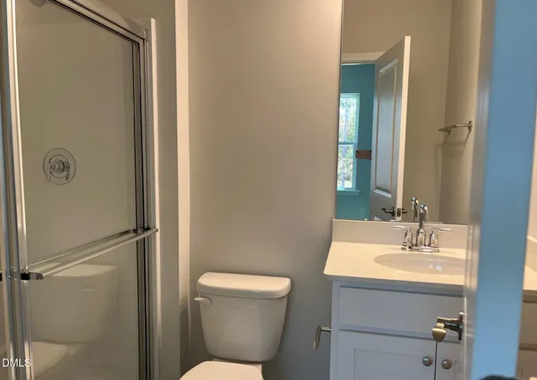 a bathroom with a toilet a sink and mirror