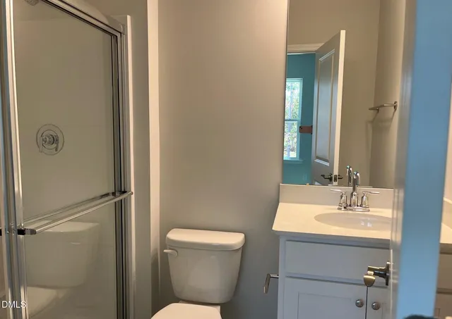 a bathroom with a toilet a sink and mirror