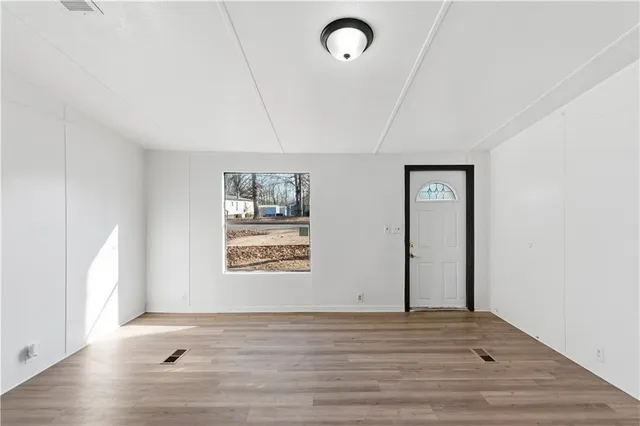 wooden floor in an empty room with a window