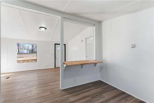 an empty room with wooden floor and window