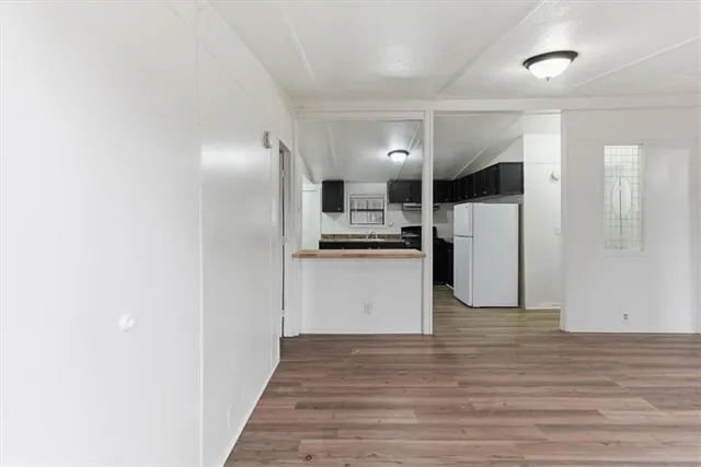 an empty room with wooden floor and window
