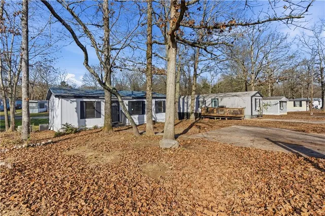 a view of a house with a yard and large tree