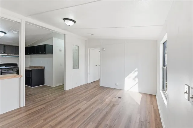 a view of empty room with wooden floor