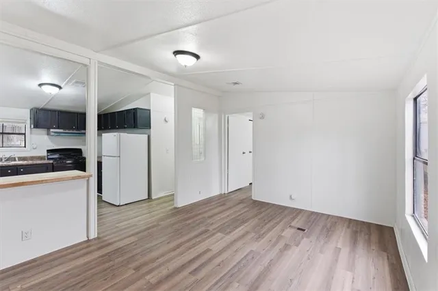 a kitchen with stainless steel appliances kitchen island sink refrigerator and cabinets