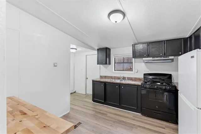 a view of kitchen with refrigerator microwave and stove