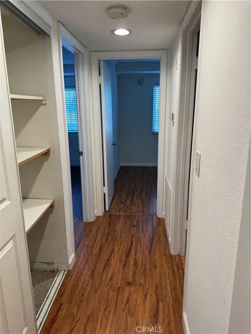 a view of a hallway with wooden floor and staircase