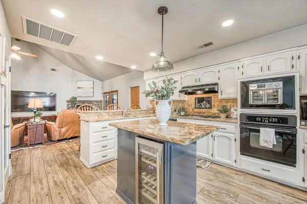a kitchen with a sink a stove and chairs
