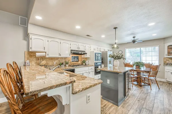 a kitchen with stainless steel appliances granite countertop a sink and cabinets