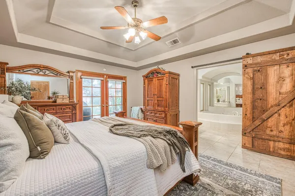 a bathroom with a granite countertop tub double vanity sink and a large mirror