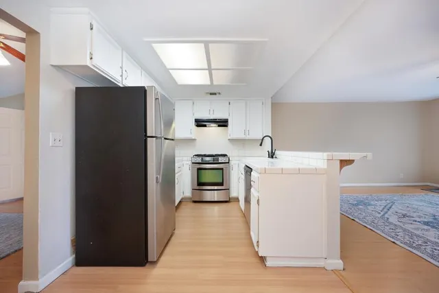 a kitchen with white cabinets stainless steel appliances and sink