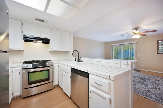 a kitchen with stainless steel appliances granite countertop a refrigerator sink and stove