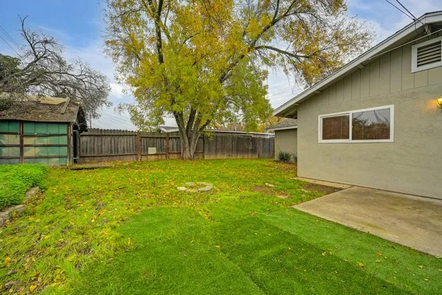 a backyard of a house with table and chairs
