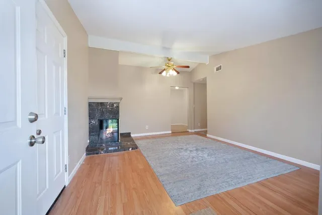 a view of a livingroom with a fireplace wooden floor and staircase