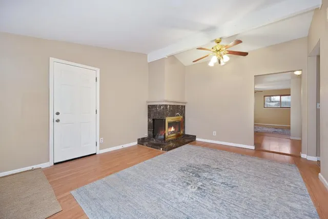 a view of a livingroom with a fireplace and a chandelier fan