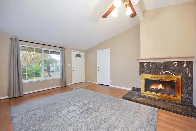 a view of an empty room with a fireplace and window