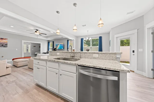 a kitchen with a sink stove and wooden floor