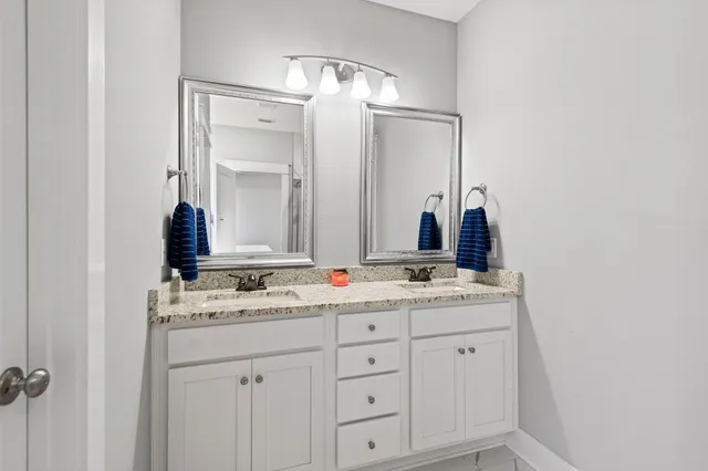 a bathroom with a double vanity sink and mirror