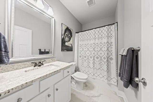a bathroom with a granite countertop sink toilet and shower