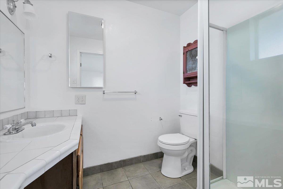 1630 Dayton Way Reno, NV 89502 - Photo 10 of 36 a bathroom with a toilet sink and mirror